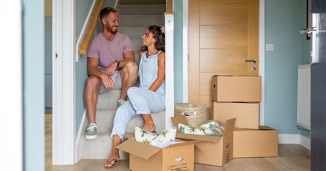 Devonshire Homes Deposit Unlock Scheme Couple On Stairs With Moving Boxes 1120